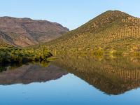 Berge im sanften Abendlicht spiegeln sich im Fluß